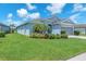 Charming single-story home with lush front lawn, beautiful landscaping, and a gray two-car garage at 5539 Silver Sun Dr, Apollo Beach, FL 33572