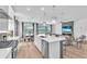 Open kitchen with white cabinets, quartz countertops, stainless steel appliances, and an adjacent dining and living area at 5539 Silver Sun Dr, Apollo Beach, FL 33572