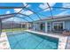 Rear of the house and patio area looking over a pool with lake views and a screened-in enclosure at 5539 Silver Sun Dr, Apollo Beach, FL 33572