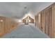 Attic with blue carpet and wood paneled walls featuring vaulted ceilings, closet and natural lighting at 5603 Palmetto Rd, New Port Richey, FL 34652