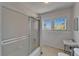 Bathroom with shower featuring pink tiles and a bright window with natural lighting at 5603 Palmetto Rd, New Port Richey, FL 34652