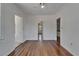 Bedroom with hardwood floors and crisp white wall paneling, featuring multiple doorways to adjoining rooms at 5603 Palmetto Rd, New Port Richey, FL 34652