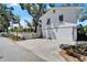 Side exterior offers driveway parking leading to an attached garage and stairs to the deck at 5603 Palmetto Rd, New Port Richey, FL 34652