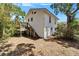 Home's rear exterior shows deck, stairs to yard, and access to under-house garage or storage at 5603 Palmetto Rd, New Port Richey, FL 34652