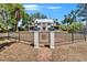 Captivating two-story home with manicured lawn, decorative metal gate, and brick walkway at 5603 Palmetto Rd, New Port Richey, FL 34652