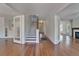 Spacious hallway featuring hardwood floors, staircase, and glass paneled doors at 5603 Palmetto Rd, New Port Richey, FL 34652