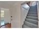Hallway featuring stairway and doorways to additional rooms, with mixed wood and carpeted floors at 5603 Palmetto Rd, New Port Richey, FL 34652