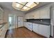 Kitchen with hardwood floors, white cabinetry, and modern appliances at 5603 Palmetto Rd, New Port Richey, FL 34652