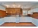 Compact kitchen with wooden shelves, white appliances, and laminate countertops, offering a functional space at 5603 Palmetto Rd, New Port Richey, FL 34652