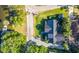 Birds-eye view of property showcasing lush greenery, dark metal roofing, paver driveway, and waterfront access at 5610 N River Shore Dr, Tampa, FL 33603