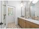 Charming bathroom with dual vanities, designer mirrors, and patterned floor tiles for a classic touch at 5610 N River Shore Dr, Tampa, FL 33603