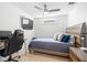 Modern bedroom featuring neutral colors, a ceiling fan, TV, desk, and a wood-accented bed frame at 5610 N River Shore Dr, Tampa, FL 33603