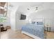 Comfortable bedroom features hardwood floors, a TV, a ceiling fan, and a white headboard with blue patterned bedding at 5610 N River Shore Dr, Tampa, FL 33603