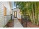 Charming entry featuring a teal door, tropical landscaping, and a welcoming walkway at 5610 N River Shore Dr, Tampa, FL 33603