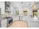 Modern white kitchen with chevron backsplash, stainless appliances, and natural light at 5610 N River Shore Dr, Tampa, FL 33603