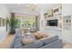 Spacious living room features a large sofa, built-in shelves, tv and decor, and water views at 5610 N River Shore Dr, Tampa, FL 33603