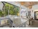 Inviting outdoor kitchen features a built-in grill, granite countertops, stylish tile, and a dining area with chandeliers at 5610 N River Shore Dr, Tampa, FL 33603