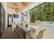 Inviting outdoor kitchen with a dining area, TV, built-in grill, granite countertops, and stylish tile at 5610 N River Shore Dr, Tampa, FL 33603