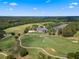 Expansive aerial view of a meticulously maintained golf course, clubhouse and lush landscaping under a bright blue sky at 5865 Creek Ridge Rd, Brooksville, FL 34601