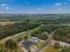 Expansive aerial view showcasing a modern home near a lush golf course under a bright, partly cloudy sky at 5865 Creek Ridge Rd, Brooksville, FL 34601