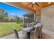 Covered dining area with stone-tile flooring and a view to the backyard and mature landscaping at 5865 Creek Ridge Rd, Brooksville, FL 34601