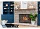 Close-up of a stone fireplace with a wooden mantle, flanked by custom blue shelving at 5865 Creek Ridge Rd, Brooksville, FL 34601