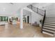 Bright, open-concept foyer with hardwood floors, staircase, kitchen view, and elegant decor at 5865 Creek Ridge Rd, Brooksville, FL 34601