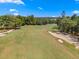 Tranquil view of the lush green golf course featuring a sand trap, surrounded by mature trees at 5865 Creek Ridge Rd, Brooksville, FL 34601