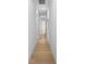 Long hallway with hardwood floors and crisp white walls leading to various rooms at 5865 Creek Ridge Rd, Brooksville, FL 34601