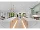Bright kitchen featuring a double island, modern appliances, light wood floors and pendant lighting at 5865 Creek Ridge Rd, Brooksville, FL 34601