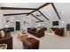 Bright living room with vaulted ceiling, exposed wood beams, neutral color palette, and comfortable seating at 5865 Creek Ridge Rd, Brooksville, FL 34601