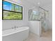 Bright bathroom features a soaking tub and glass shower with marble accents at 5865 Creek Ridge Rd, Brooksville, FL 34601