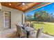 Outdoor dining on a screened patio with wooded views, fan, and comfortable seating for six at 5865 Creek Ridge Rd, Brooksville, FL 34601