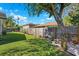 Fenced backyard with green lawn and mature trees that provide shade at 640 Kenneth Way, Tarpon Springs, FL 34689