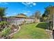 Private backyard featuring a lush lawn and well-manicured landscaping with wooden fence for privacy at 640 Kenneth Way, Tarpon Springs, FL 34689