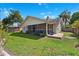 Beautifully landscaped backyard features a screened lanai with a peaceful view of the green lawn at 640 Kenneth Way, Tarpon Springs, FL 34689