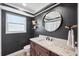 Dark bathroom featuring single sink vanity and a round mirror at 640 Kenneth Way, Tarpon Springs, FL 34689