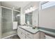 Well-lit bathroom features a tiled shower with glass door, large mirror, and vanity with plenty of counter space at 640 Kenneth Way, Tarpon Springs, FL 34689