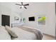 Bright bedroom featuring wood floors, a ceiling fan, and plenty of natural light from two windows at 640 Kenneth Way, Tarpon Springs, FL 34689