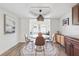 Bright dining area features modern light fixture, adjacent to kitchen with view into sitting room at 640 Kenneth Way, Tarpon Springs, FL 34689