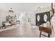 Open-concept entryway with wood-look flooring, modern decor, spiral stairs and black front doors at 640 Kenneth Way, Tarpon Springs, FL 34689