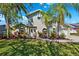 Charming two-story home with lush tropical landscaping, a circular window and an attached two car garage at 640 Kenneth Way, Tarpon Springs, FL 34689