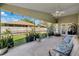 Relaxing screened in porch with neutral outdoor furniture and views of the lush landscaped backyard with privacy fence at 640 Kenneth Way, Tarpon Springs, FL 34689