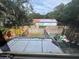 Backyard view including a fence, green grass and a barn-style building in the background at 6405 Osprey Lake Cir, Riverview, FL 33578