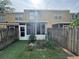 Back exterior view of townhouse with a sunroom and a fenced-in astroturf backyard at 6405 Osprey Lake Cir, Riverview, FL 33578