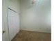 A bedroom with neutral walls and flooring, plus a closet with bi-fold doors at 6405 Osprey Lake Cir, Riverview, FL 33578