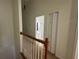 Upstairs hallway with wood railing and closet, leading to a bathroom with vanity and toilet at 6405 Osprey Lake Cir, Riverview, FL 33578