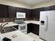 Well-equipped kitchen with white appliances, tile backsplash, and ample cabinet space at 6405 Osprey Lake Cir, Riverview, FL 33578