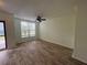 Bright living room with wood-look tile floors, a ceiling fan, and a large window at 6405 Osprey Lake Cir, Riverview, FL 33578