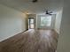 Spacious living room with wood-look tile flooring, a ceiling fan, and bright natural light at 6405 Osprey Lake Cir, Riverview, FL 33578